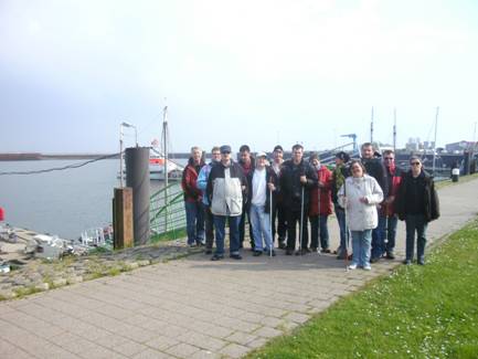 Gruppenfoto auf Borkum. Im Hintergrund ist der Hafen und der Seenotkreuzer der Küstenwache zu sehen.
